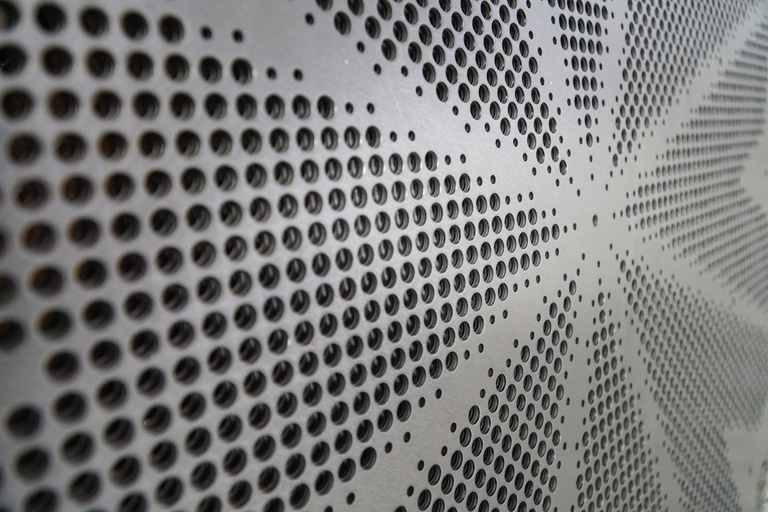 Perforated metal panels with a customized pattern designed to enhance sound-absorbing performance